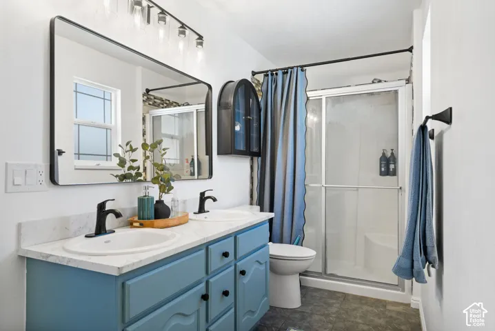Dual sink vanity with matte black fixtures, framed mirror, and track lighting