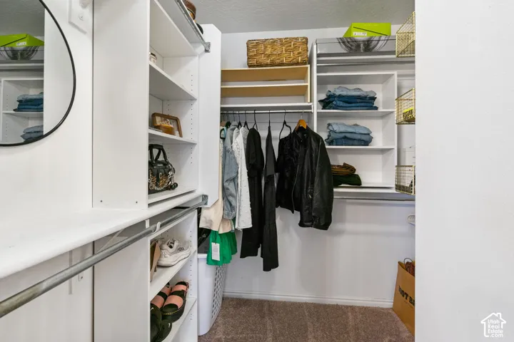 Built-in closet organization system featuring white shelving, hanging rods, and wire baskets