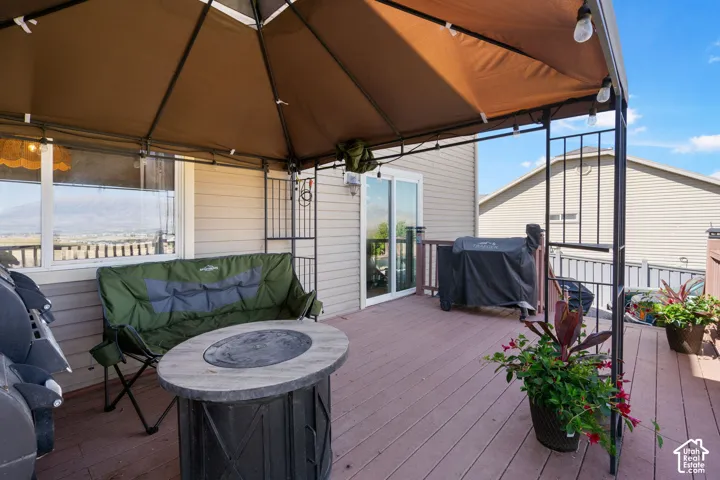 Expansive deck with a covered gazebo structure, composite decking, and sliding glass door access to the interior