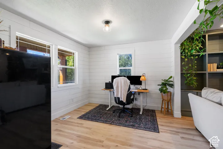 Wood-finish flooring, white shiplap wall finishes, recessed shelving, and a modern semi-flush ceiling light fixture