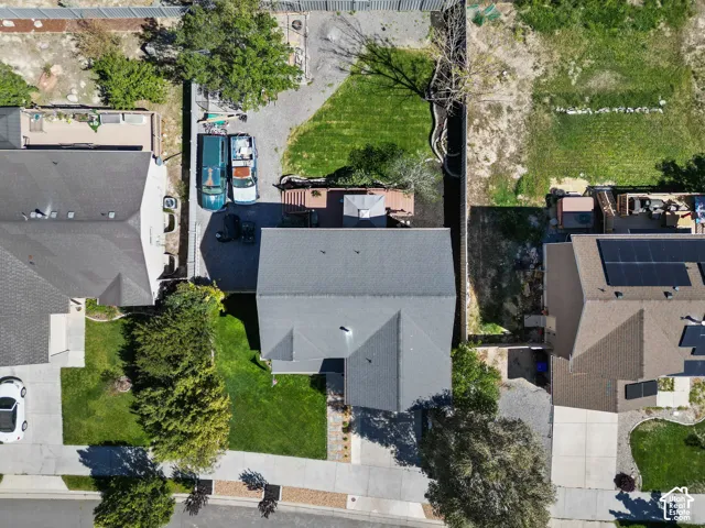 Gable roofline, asphalt shingle roofing, paved driveway, landscaped front yard, gravel hardscaping