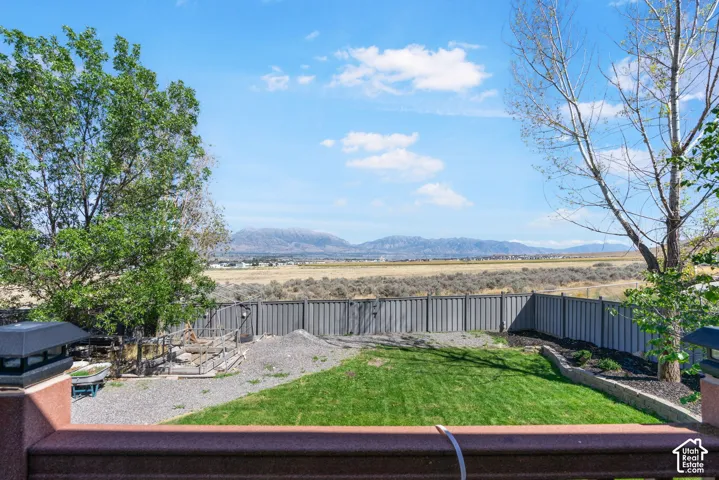 Expansive outdoor space featuring a partial lawn, gravel areas, and a privacy fence