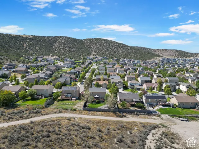 Residential neighborhood with varied architectural styles, green spaces, and mountain backdrop
