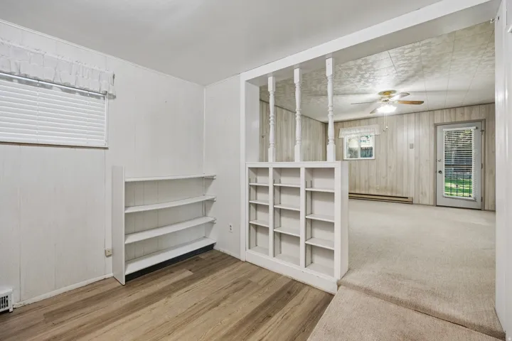 Primary bedroom sitting area bookshelves and LVP flooring