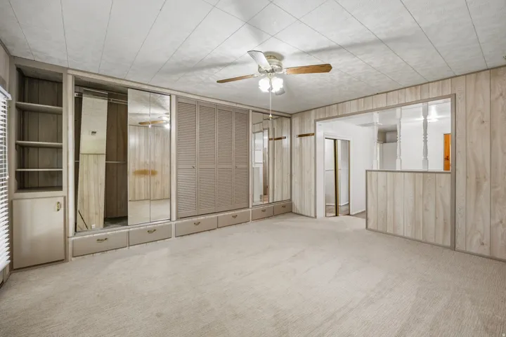 Primary bedroom with separate sitting area, ensuite bathroom, full wall of closets and direct access to the backyard