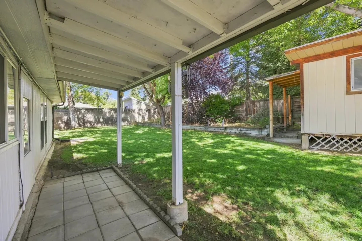 Covered patio with paver stone flooring, mature trees, fully fenced and workshop