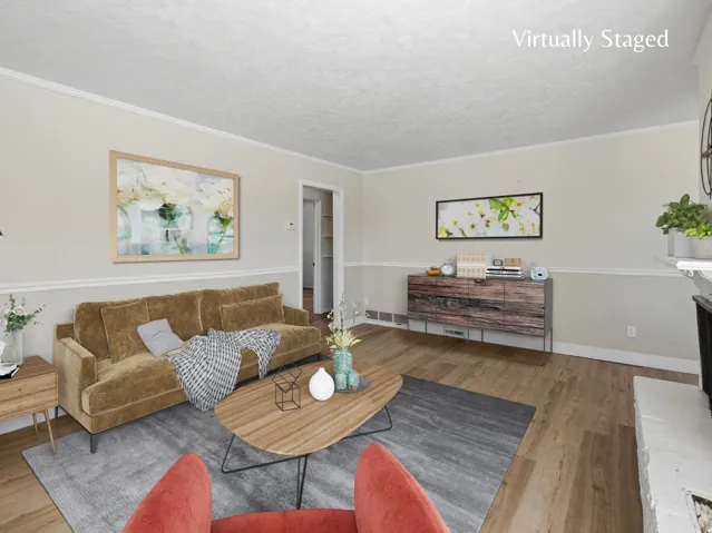 Spacious living room with welcoming fireplace and LVP flooring.  Virtually staged image