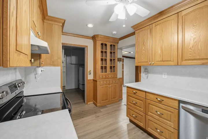 Cozy kitchen with lots of storage, stainless steel range and dishwasher, LVP flooring and built in display cabinet