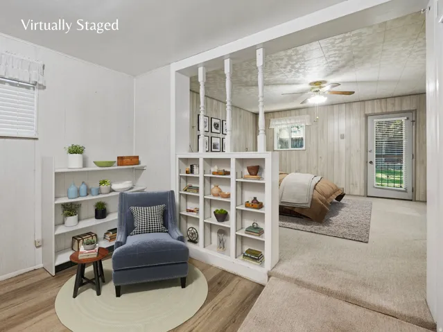 Primary bedroom sitting area bookshelves and LVP flooring.  Virtually Staged Image
