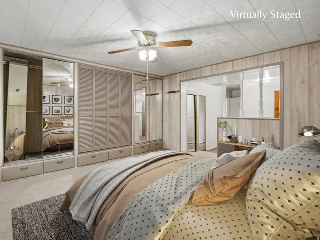 Primary bedroom with separate sitting area, ensuite bathroom, full wall of closets and direct access to the backyard.  Virtually staged image