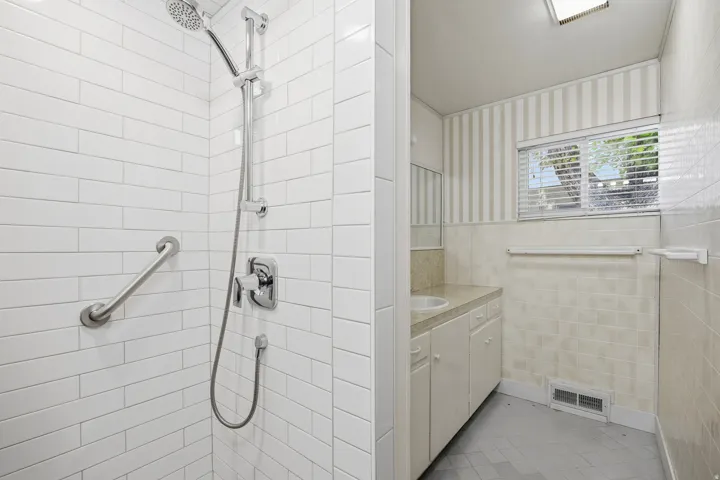 Hall bathroom with newer tile shower, tile floors and plenty of counter space