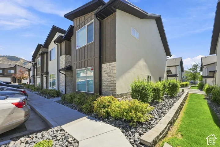 Modern multi-level townhome exteriors featuring wood paneling, stone accents, and light stucco