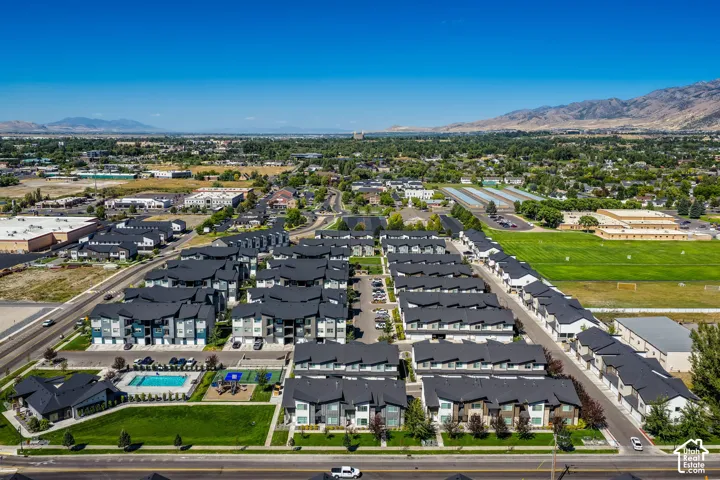 Community with multiple multi-story buildings, dark roofs, and light-colored siding