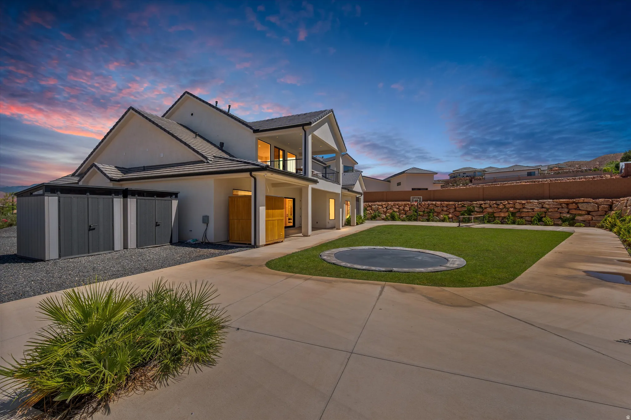 Contemporary exterior with multiple windows, an upper-level balcony, and a manicured lawn