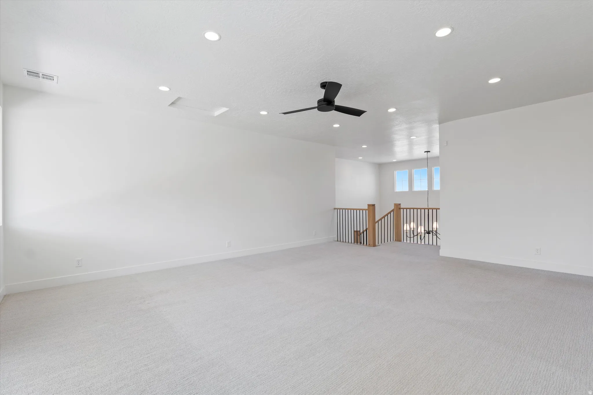 Spacious room with recessed lighting, ceiling fan, and carpeted flooring