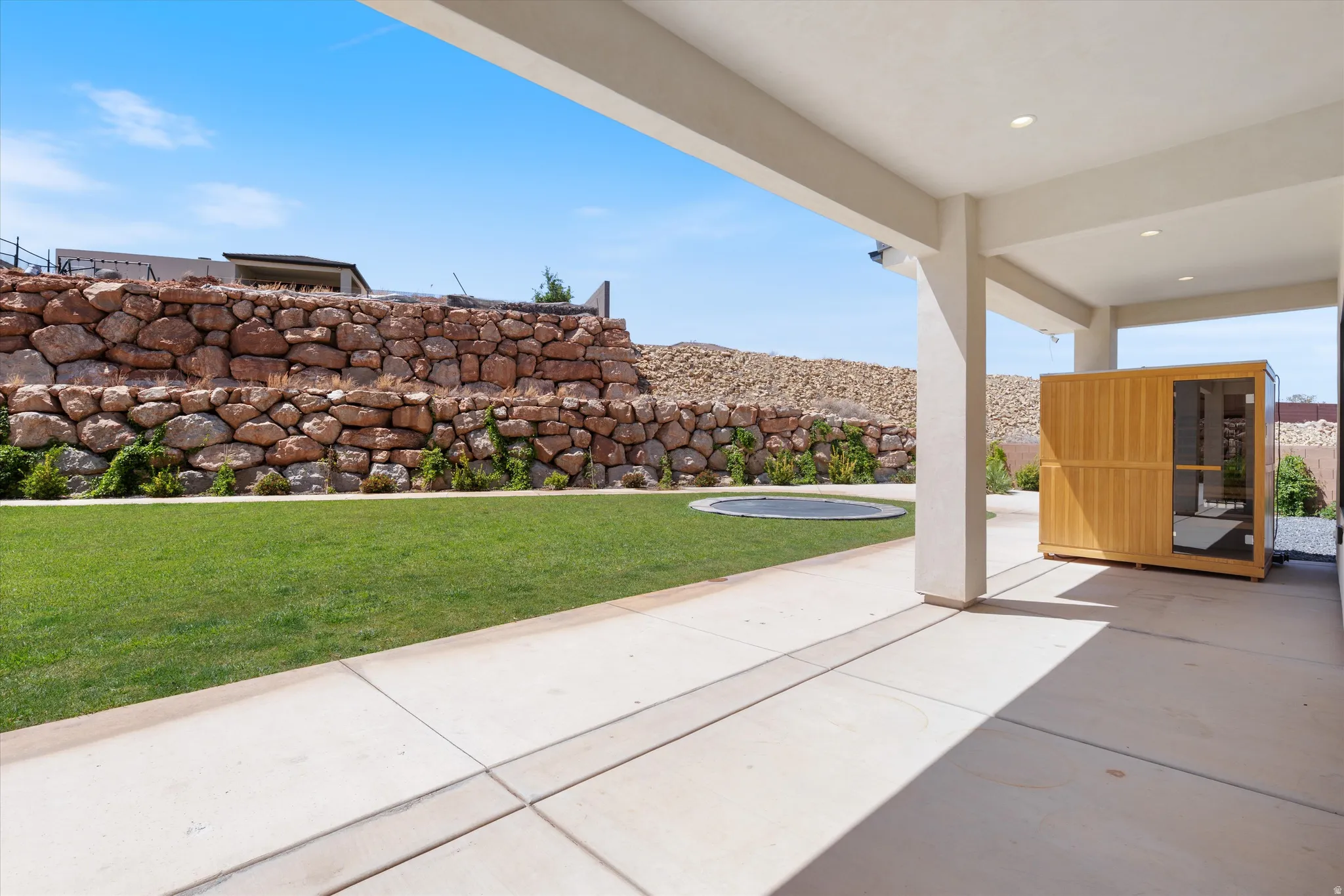 Covered patio with recessed lighting, integrated wooden sauna, and concrete flooring