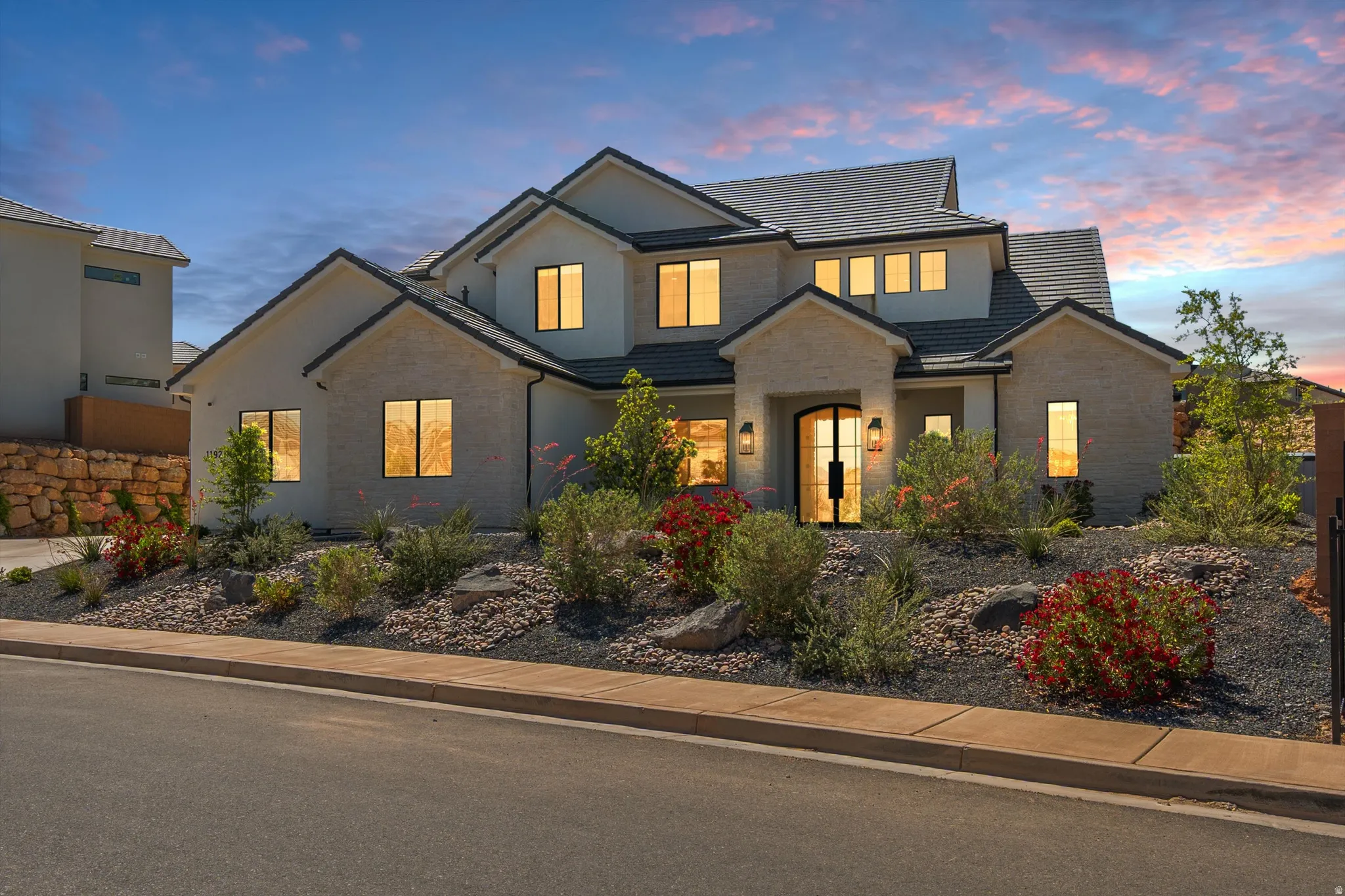 Contemporary two-story residence with a multi-gabled roofline and stone-faced and smooth stucco exterior