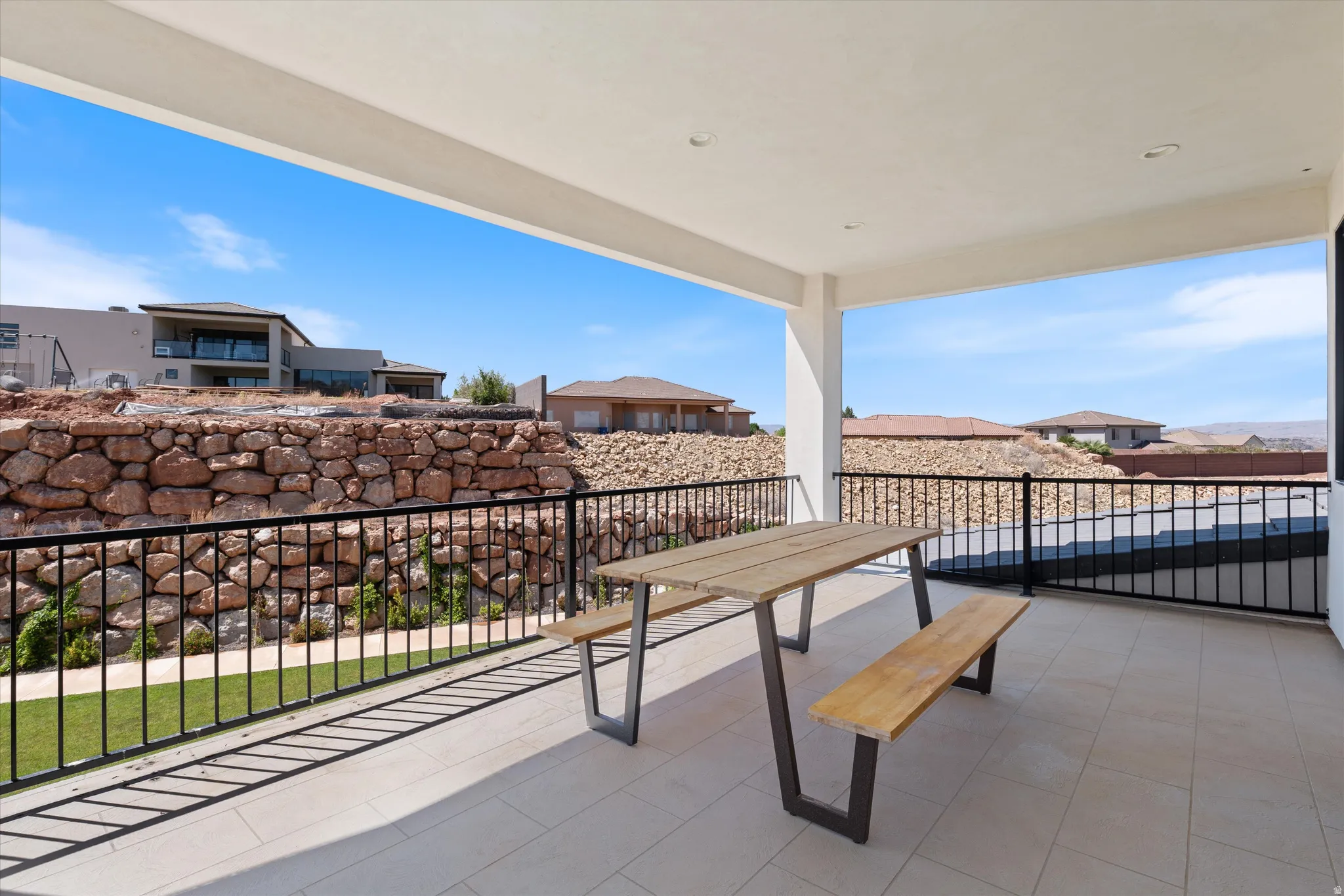 Covered patio with recessed lighting, tile flooring, and black metal railings