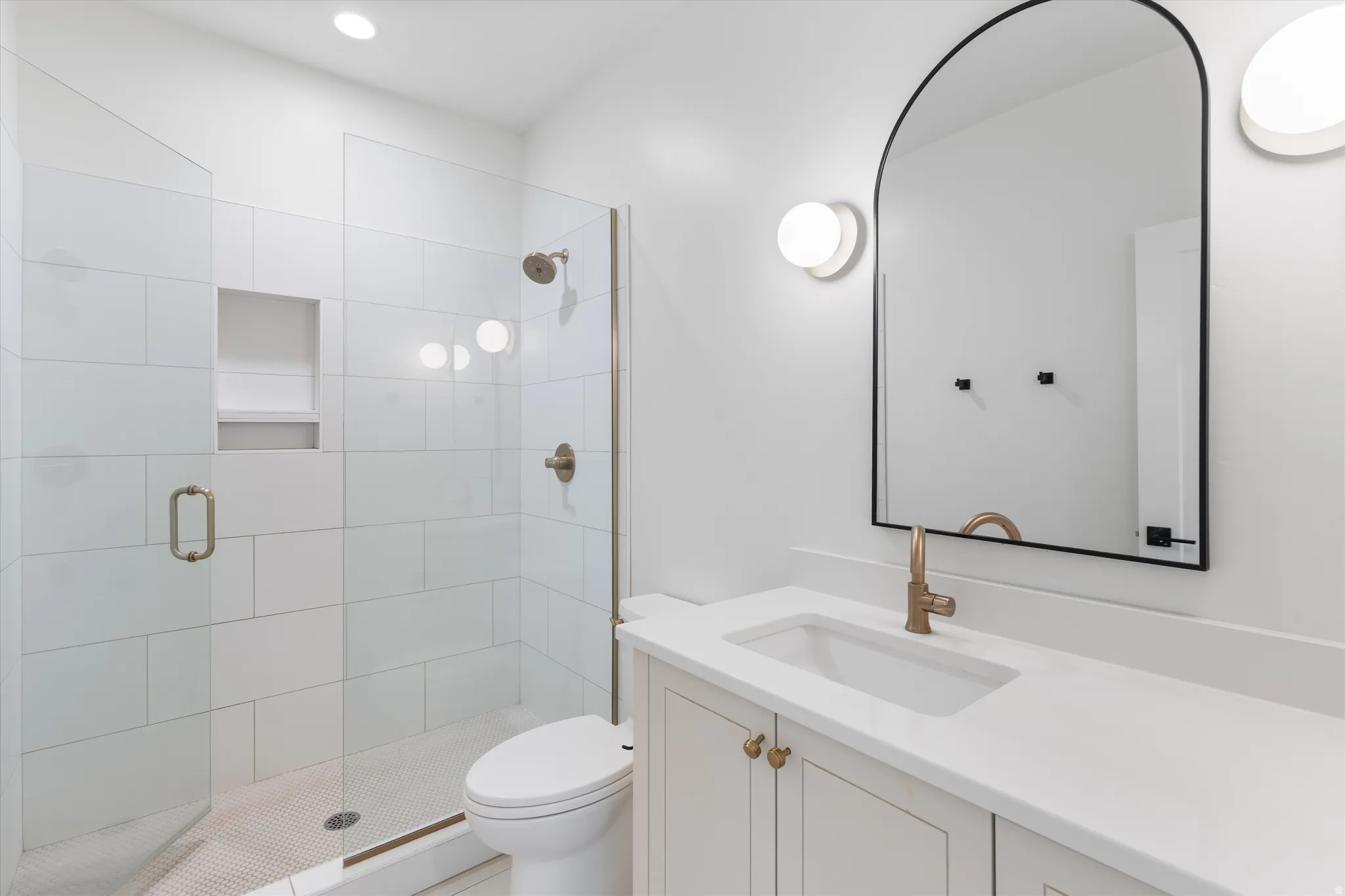 Glass-enclosed shower with subway tile surround and integrated niche
