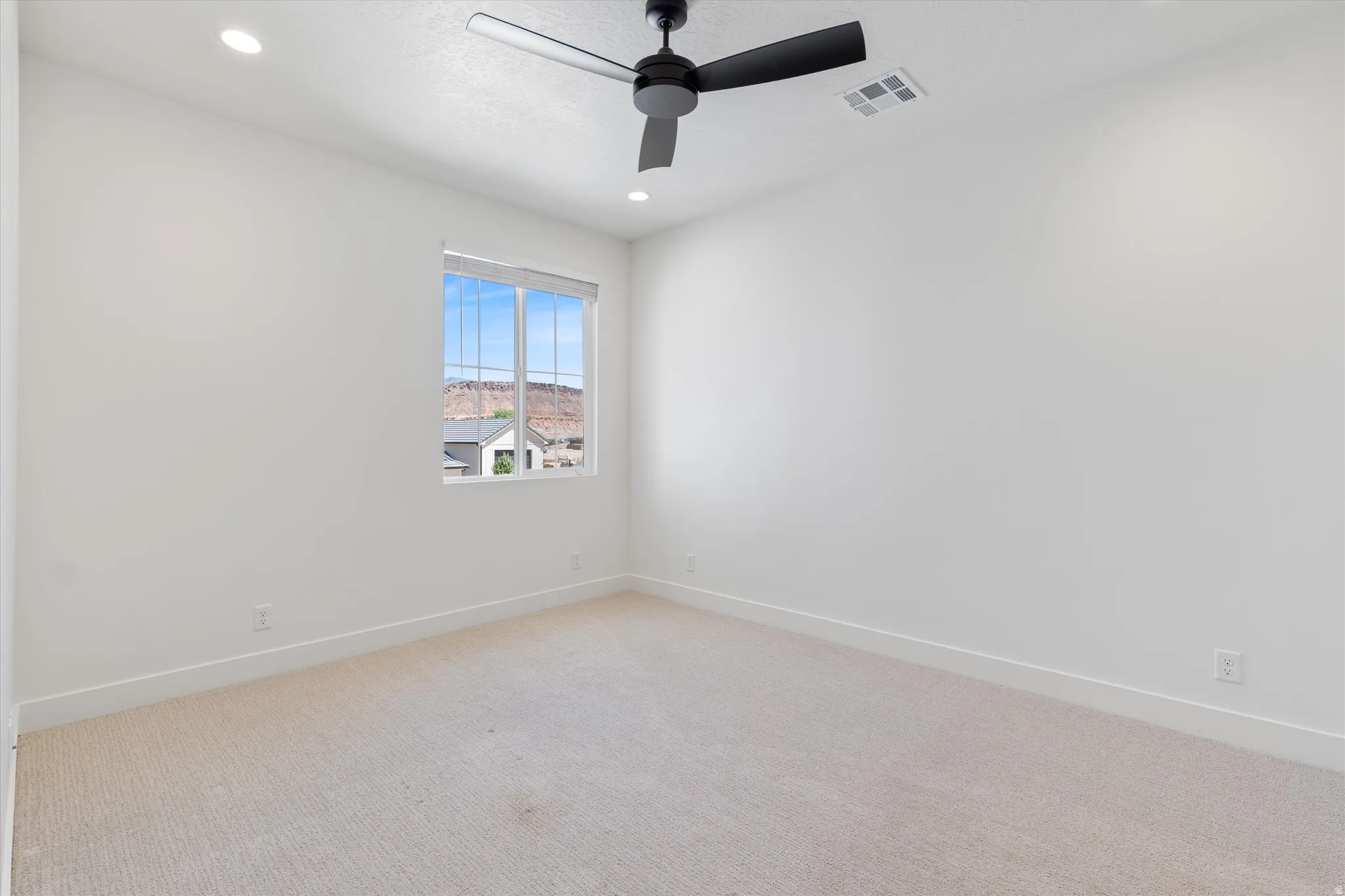 Recessed lighting, carpeted flooring, a ceiling fan, and a prominent window