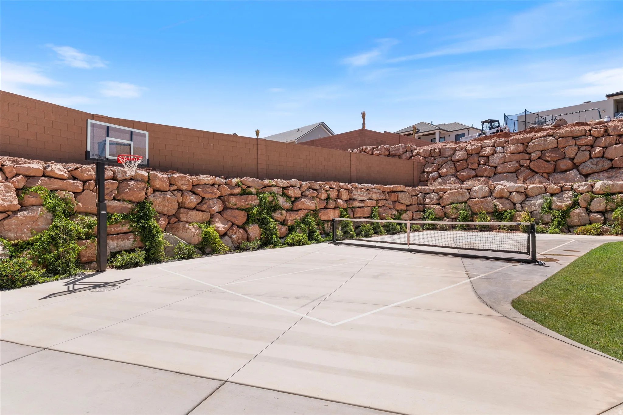 Concrete sports court with integrated basketball hoop and net