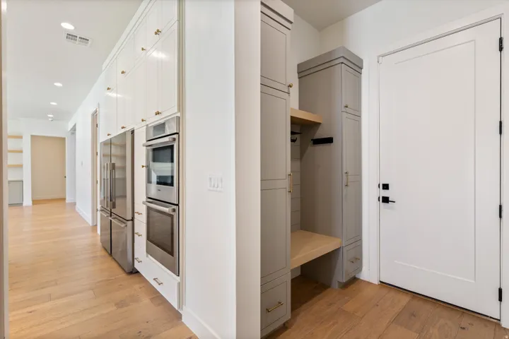 Contemporary kitchen featuring stainless steel dual wall ovens, refrigerator with French doors, and integrated appliances