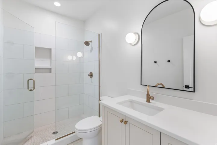 Glass-enclosed shower with subway tile surround and integrated niche