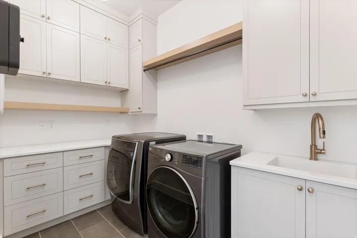 White shaker cabinetry, light-toned countertops, integrated sink, and bronze-finish faucet