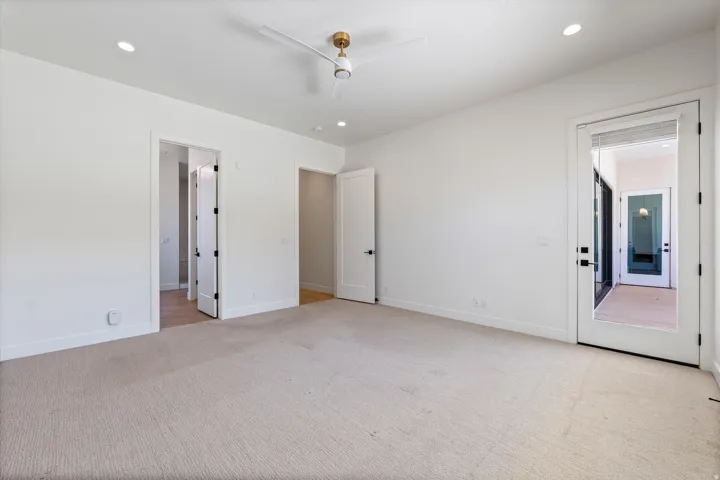 Recessed lighting, ceiling fan with brushed gold accents, white interior doors, and a glass-paneled exterior door