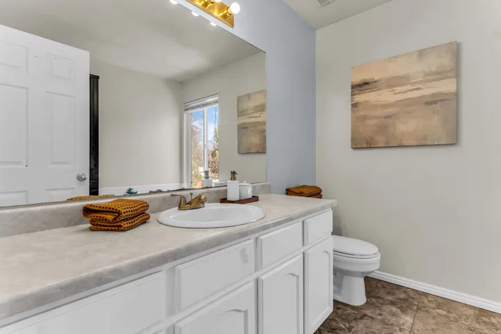 Vanity with integrated sink, gold-finish faucet, and white cabinetry