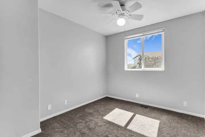 Neutral wall finishes, recessed window, and ceiling fan with integrated lighting
