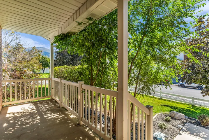 Covered porch with white railings and slatted ceiling