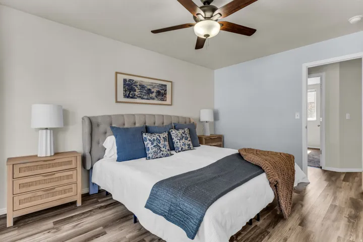 Ceiling fan with integrated lighting, wood-finish flooring, light-toned walls