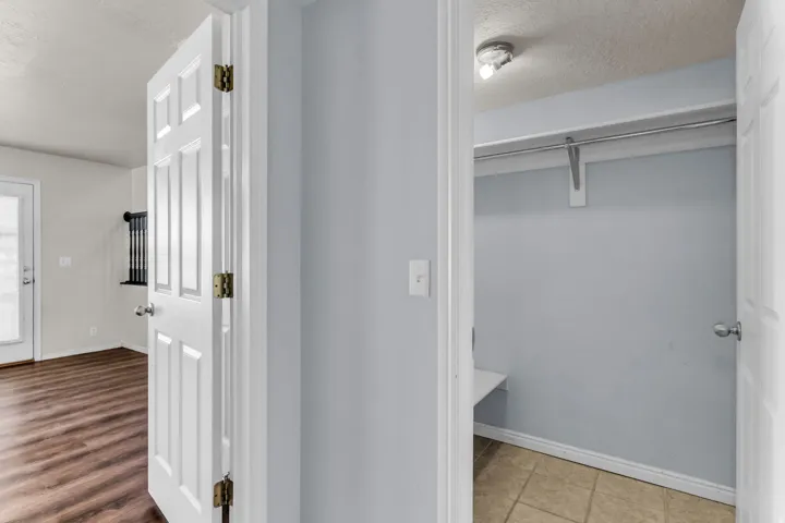 Closet space with hanging rod, integrated shelf, and ceramic tile flooring