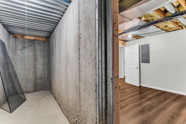 Finished basement area featuring wood-finish flooring, white paneled doors, and painted walls