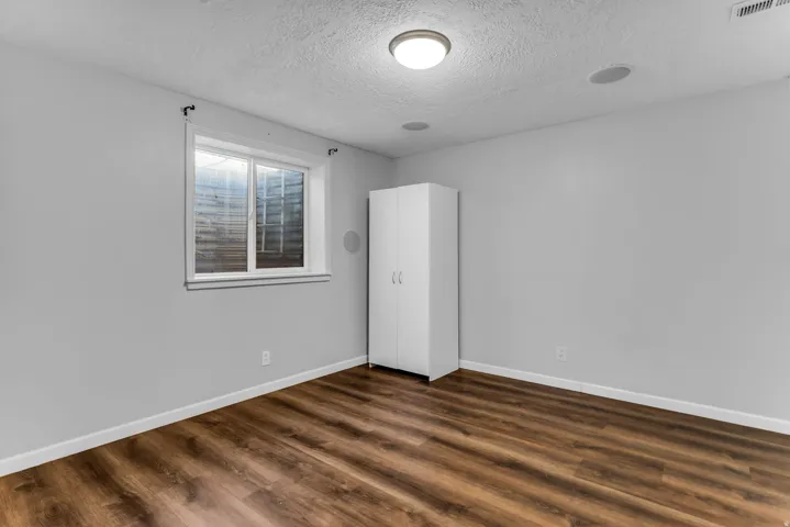 Wood-finish flooring, recessed ceiling lighting, and a single window
