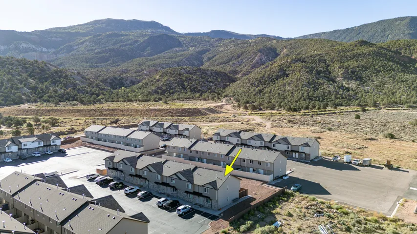 Townhome community featuring multi-story units and an asphalt parking area