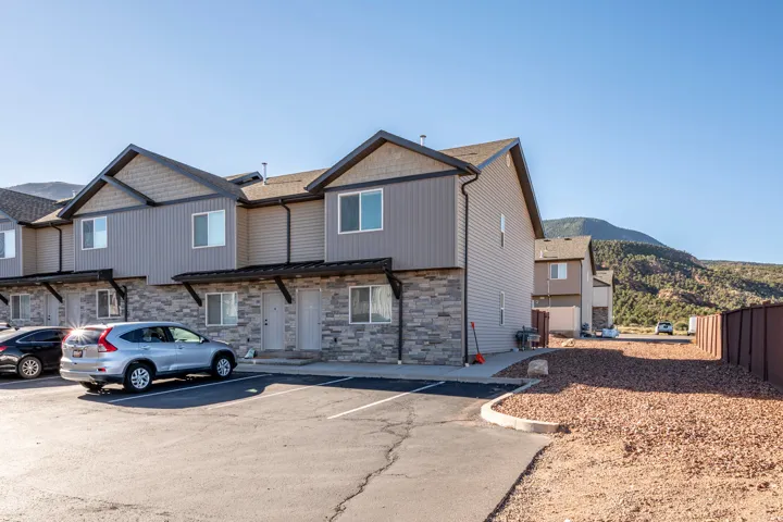 Multi-unit residential structure featuring stacked stone veneer and vertical siding accents