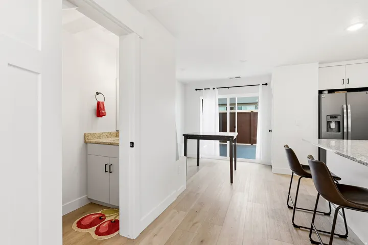 Light wood-finish flooring throughout, white baseboards, and white walls