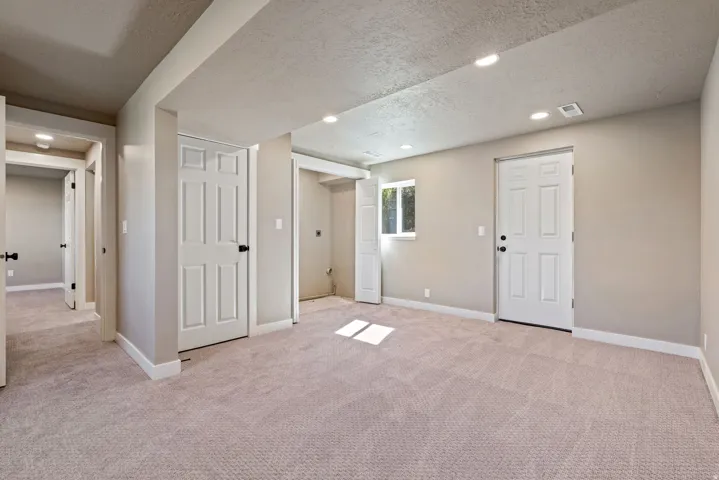 Recessed lighting, light-toned carpeting, neutral wall paint, white trim, and white paneled doors