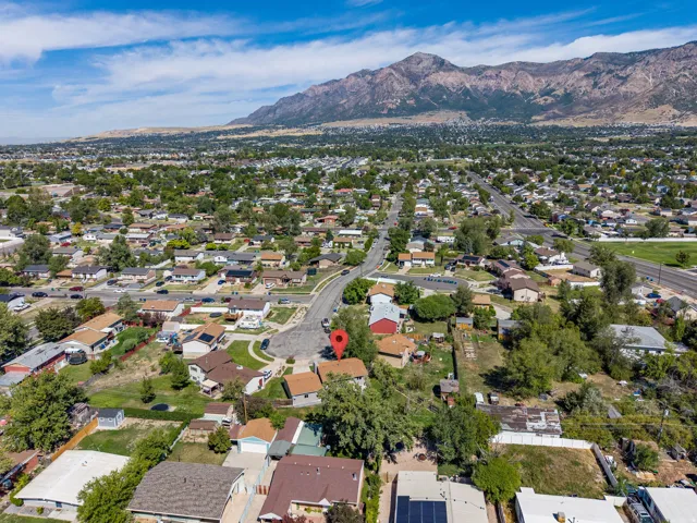 Residential neighborhood setting with mature trees and mountain backdrop