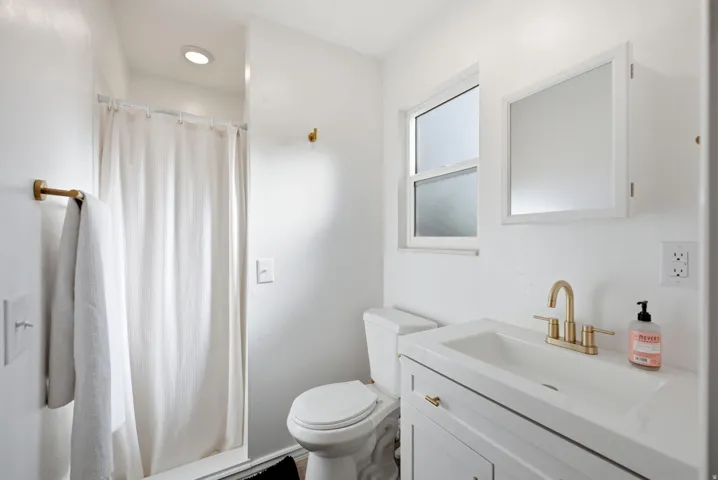 Built-in vanity with integrated sink, gold-finish faucet, and coordinating hardware