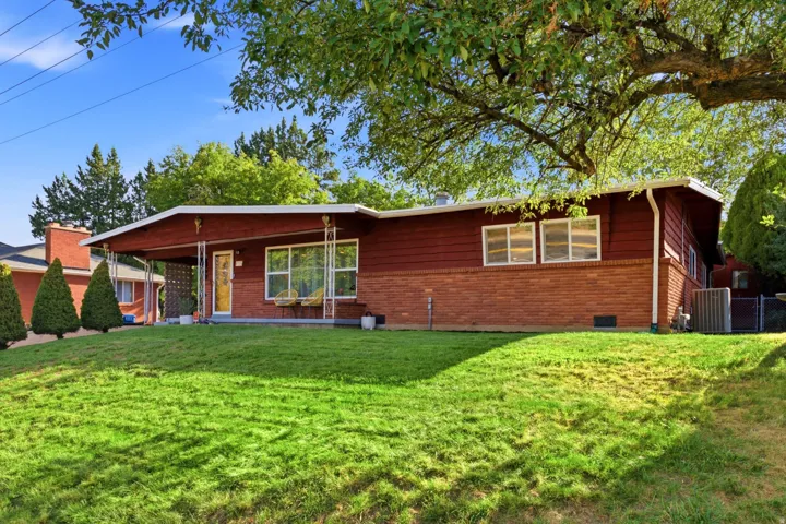 Mid-century architecture featuring a red brick and horizontal siding exterior
