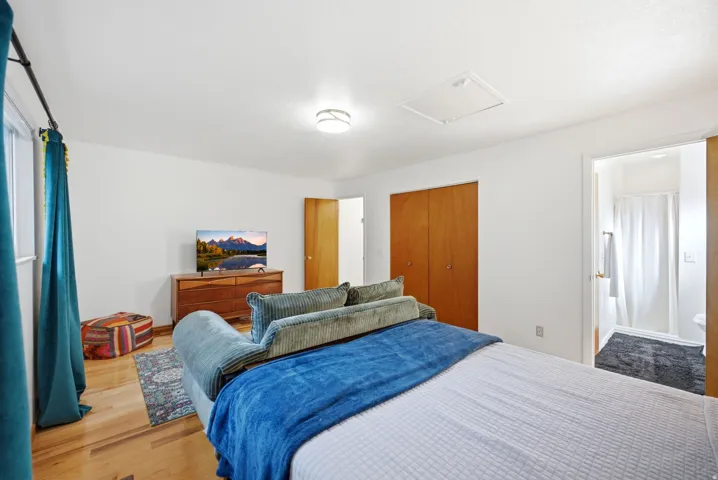 Hardwood flooring, recessed lighting, and a closet with wood doors