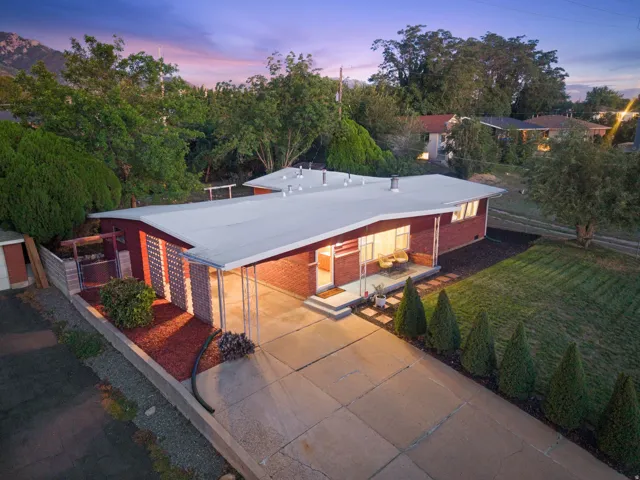 Mid-century modern residence featuring a red brick exterior, extended carport, and a flat roofline