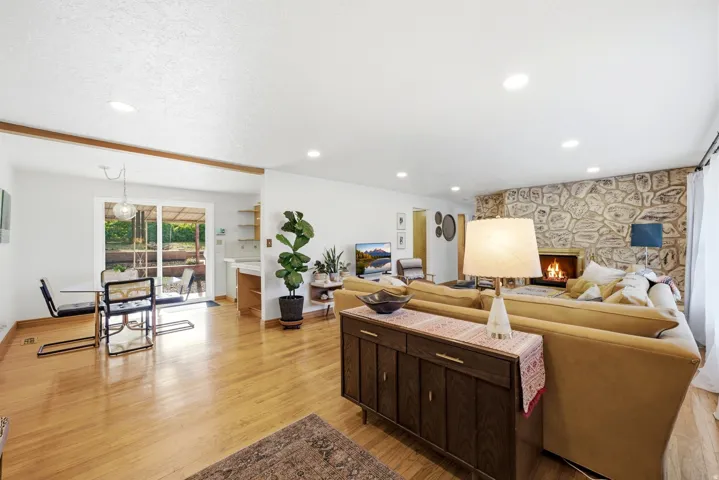Wood-finish flooring throughout, recessed lighting, and a stone-clad fireplace