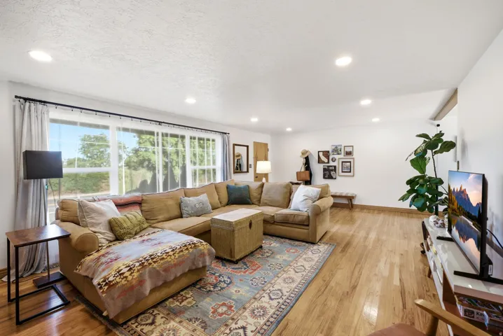 Recessed ceiling lighting, expansive windows, wood-finish flooring, and white painted walls