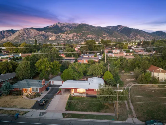 Mountain backdrop, residential setting, mature trees, paved street
