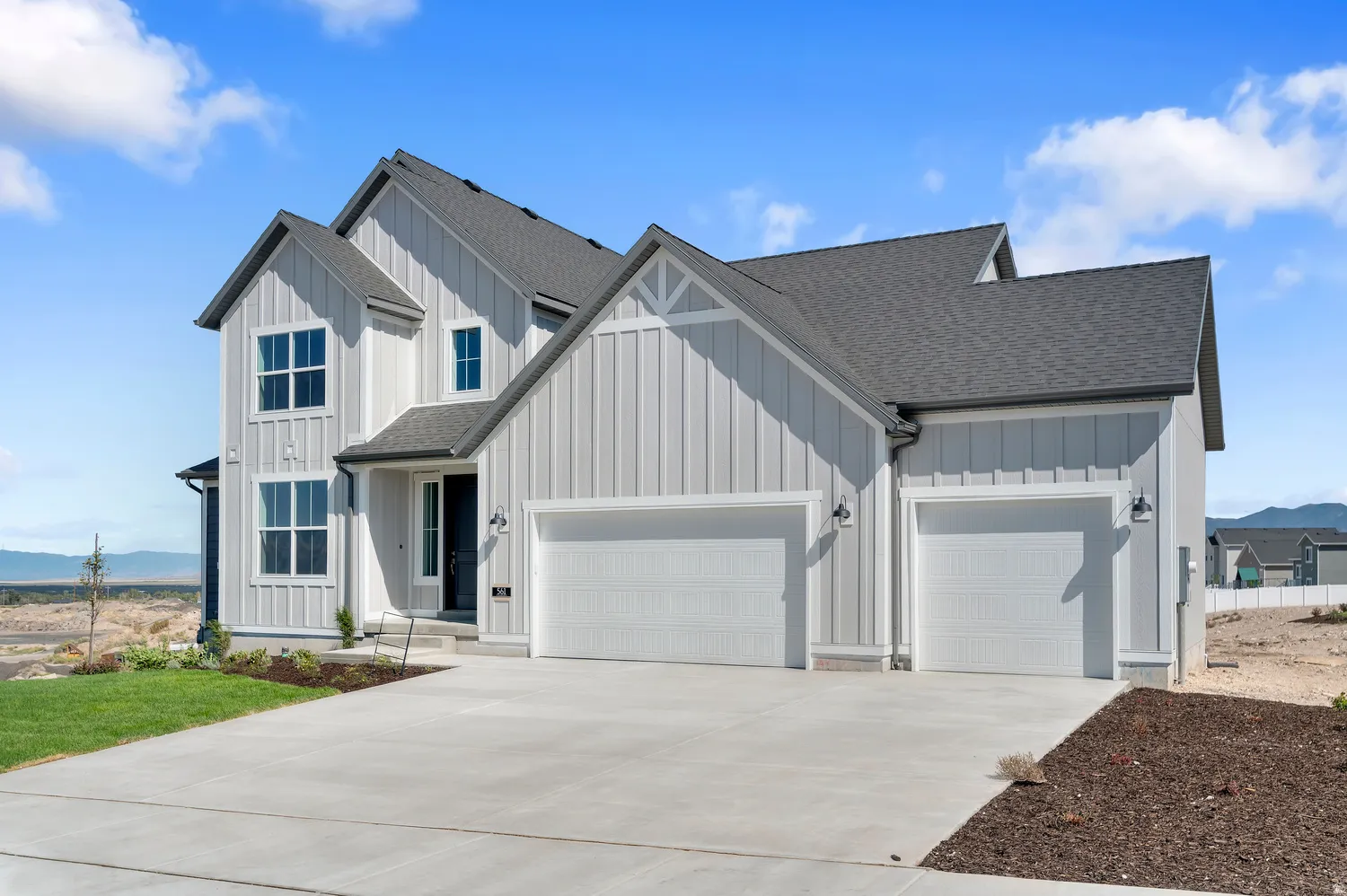 Modern farmhouse exterior with vertical siding, dark shingle roof, two-car garage, and concrete driveway