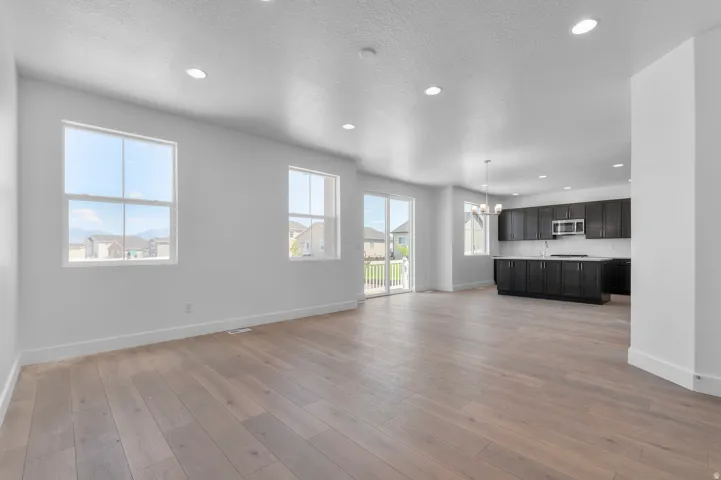 Open-concept layout with wood-finish flooring, recessed lighting, and white walls